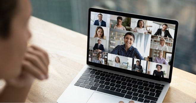 A man undergoing video training on his laptop with his team.