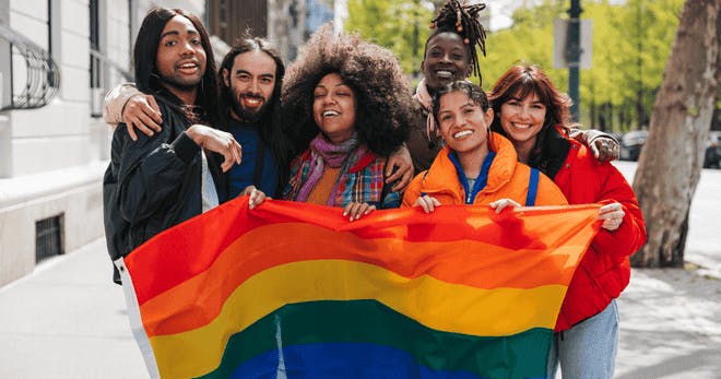 A group of people celebrating their gender identities with a flag