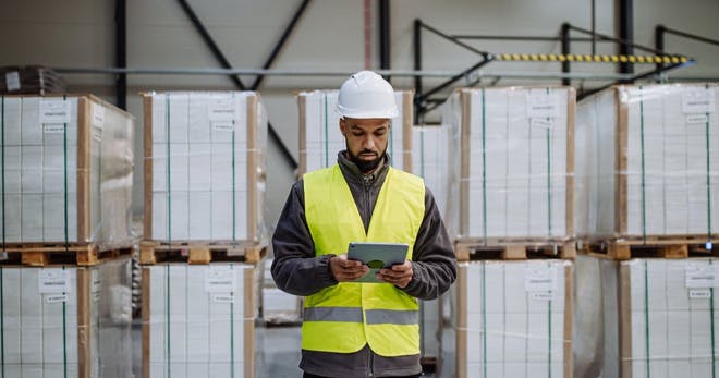 A logistics manager reading about frontline leadership training on a tablet