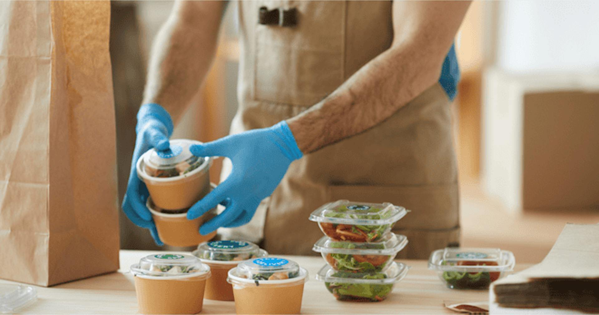 Worker packing food in containers for delivery