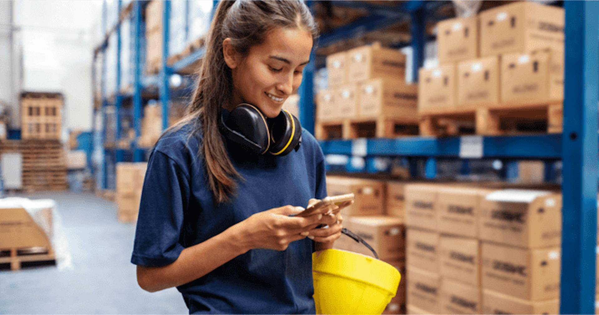 Warehouse worker using a mobile phone