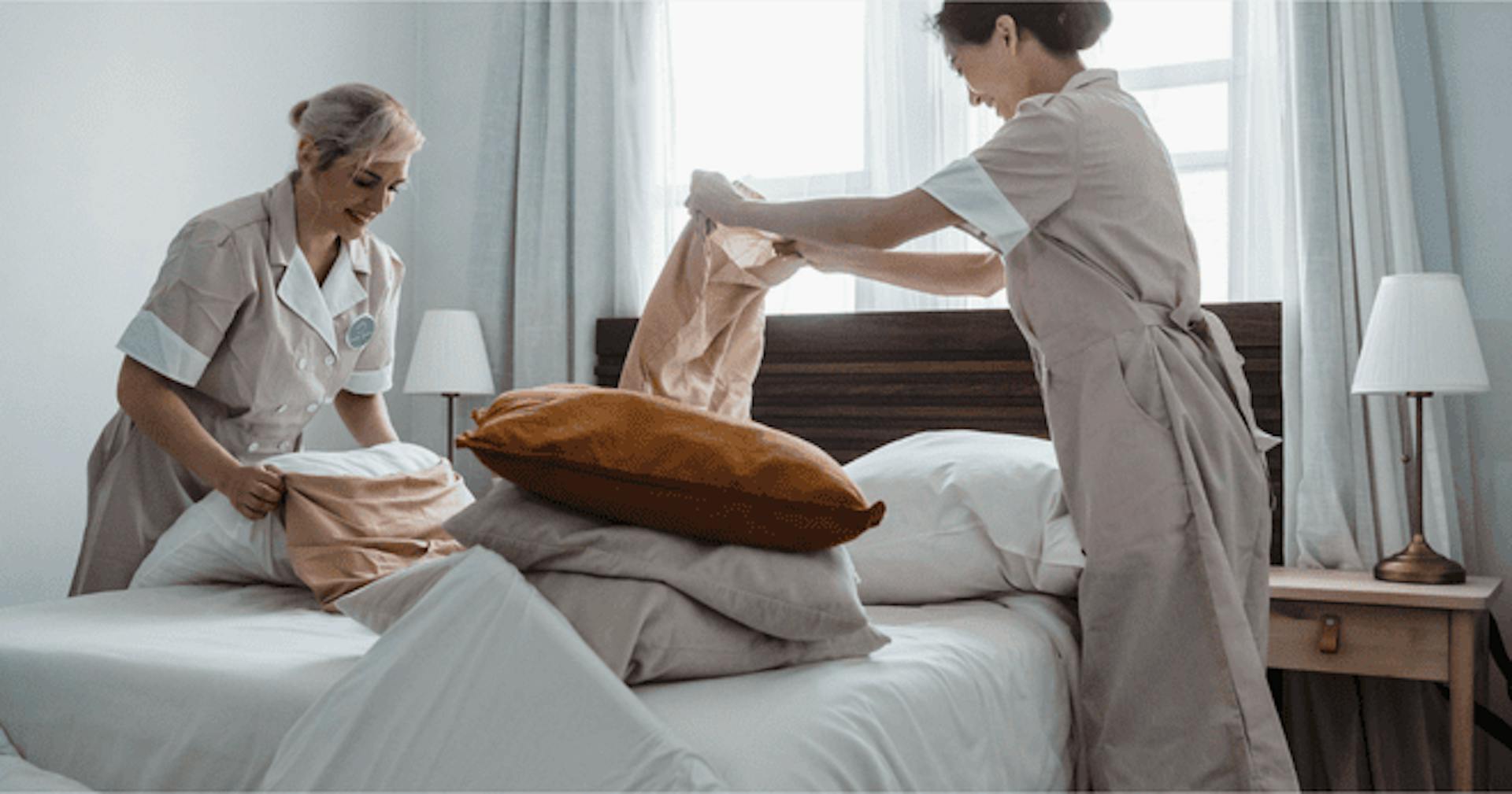 Housekeeping staff fixing a bed