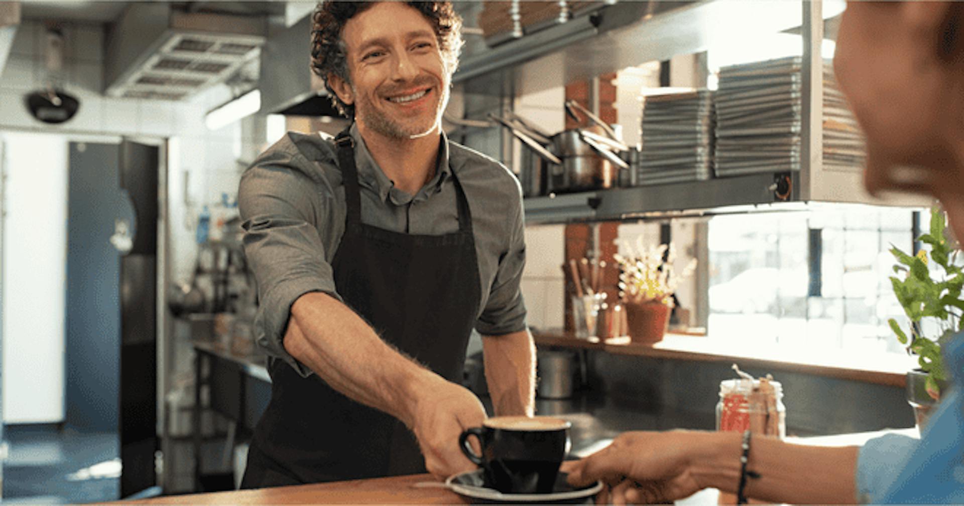 Waiter serving coffee to customer