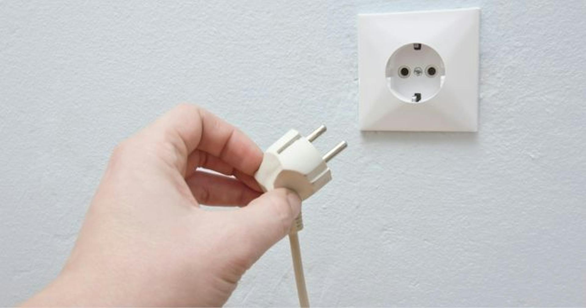 person unplugging an outlet to get rid of a fire hazard