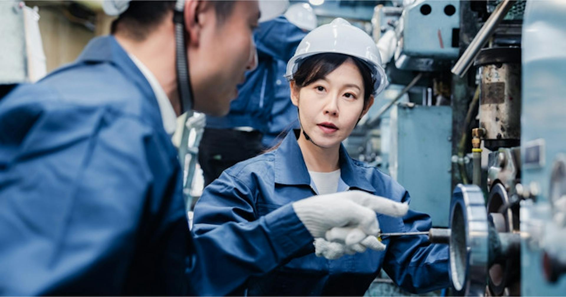 Supervisor teaching his employee about a machine