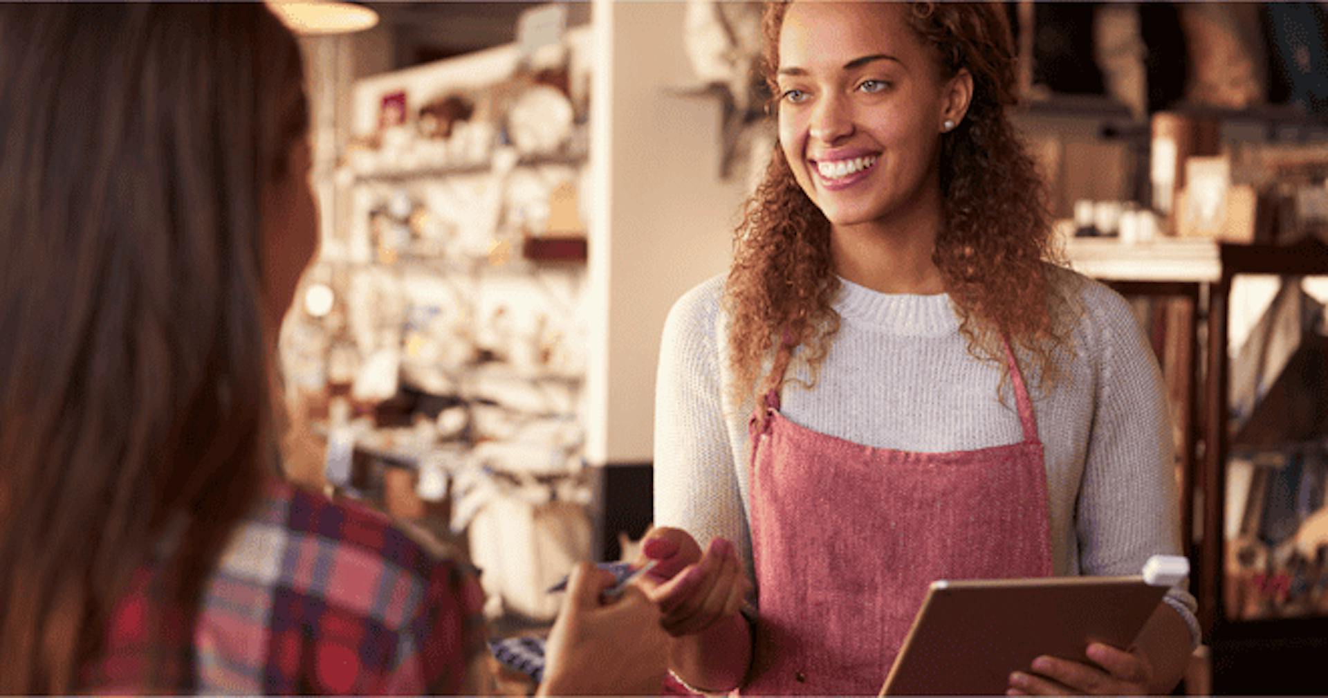 Sales assistant with credit card reader on digital tablet