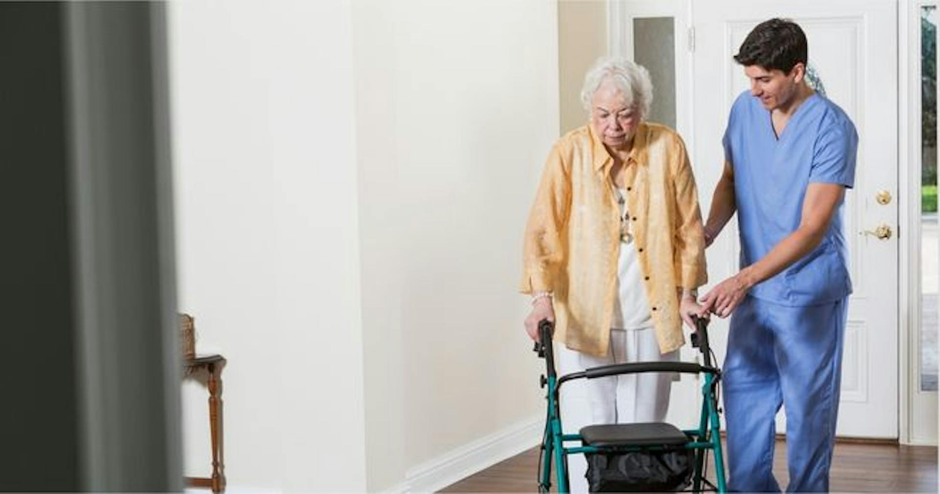 Male caregiver patiently assisting elderly woman