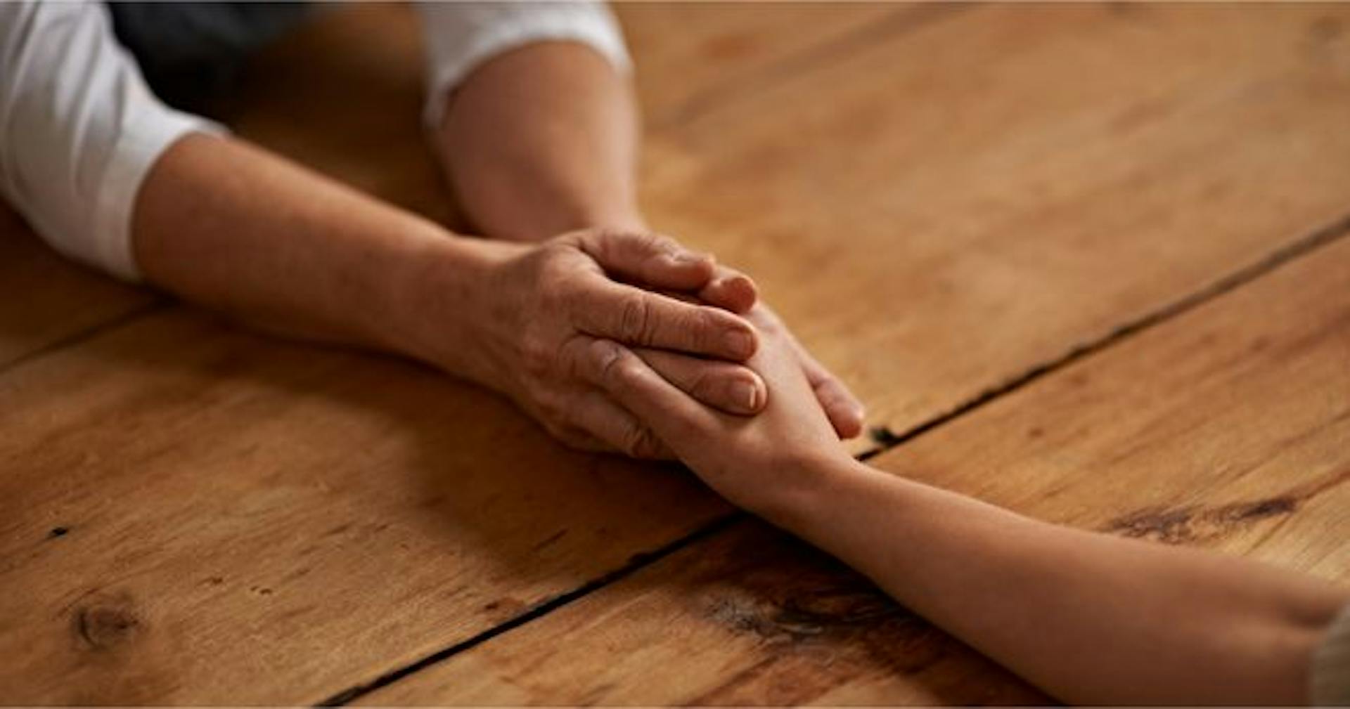 Two people holding hands and showing empathy