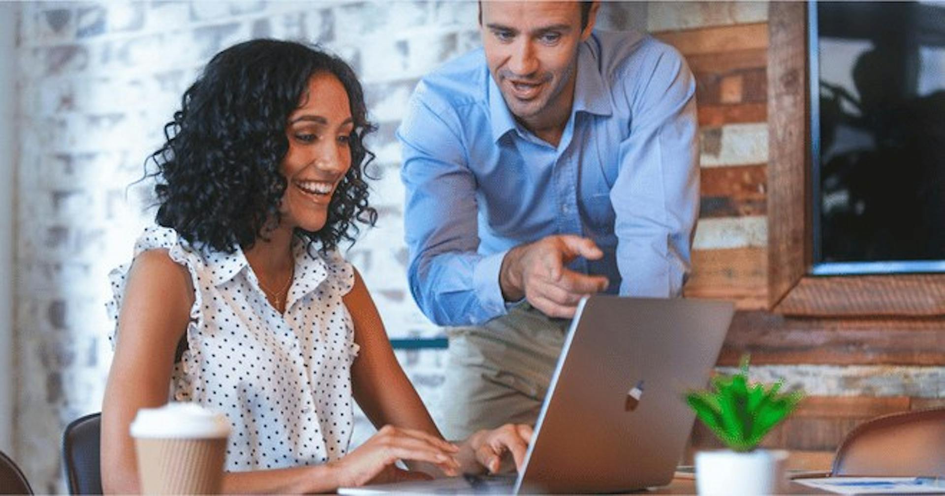 An employee teaching his co-worker about blogging for business
