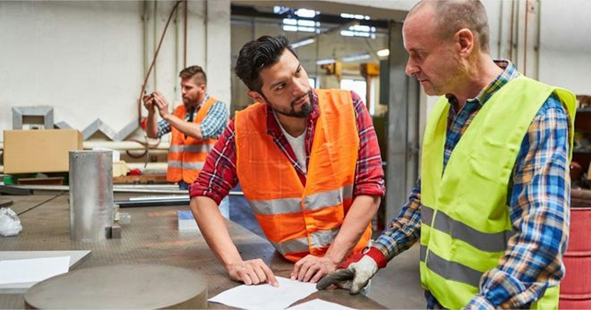 Manager teaching worker the manufacturing process