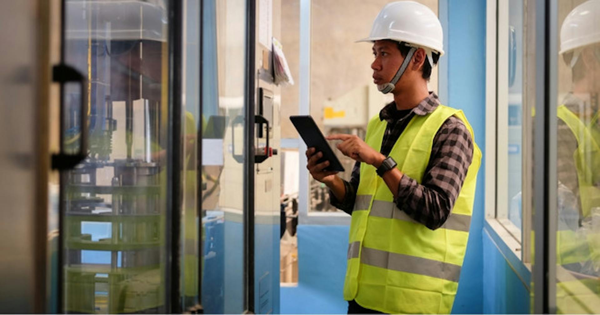 Manufacturing worker referencing SOPs while working