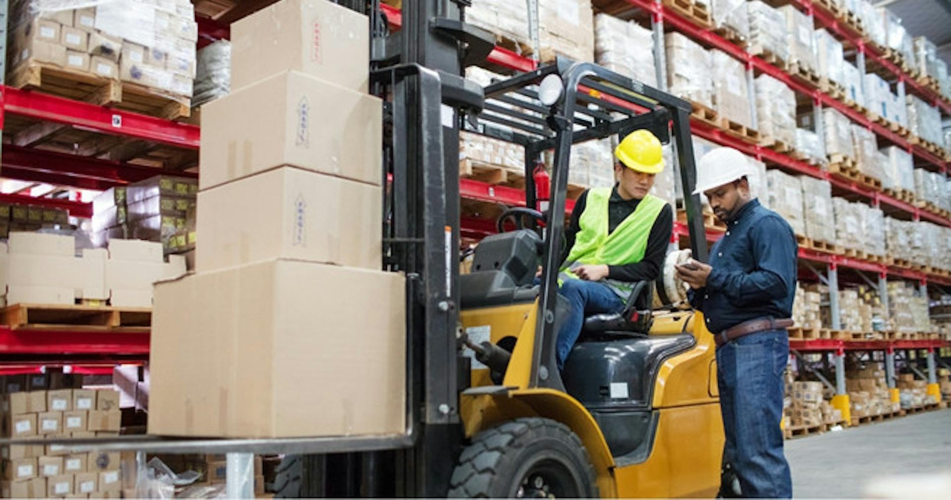 Floor manager evaluating forklift operator