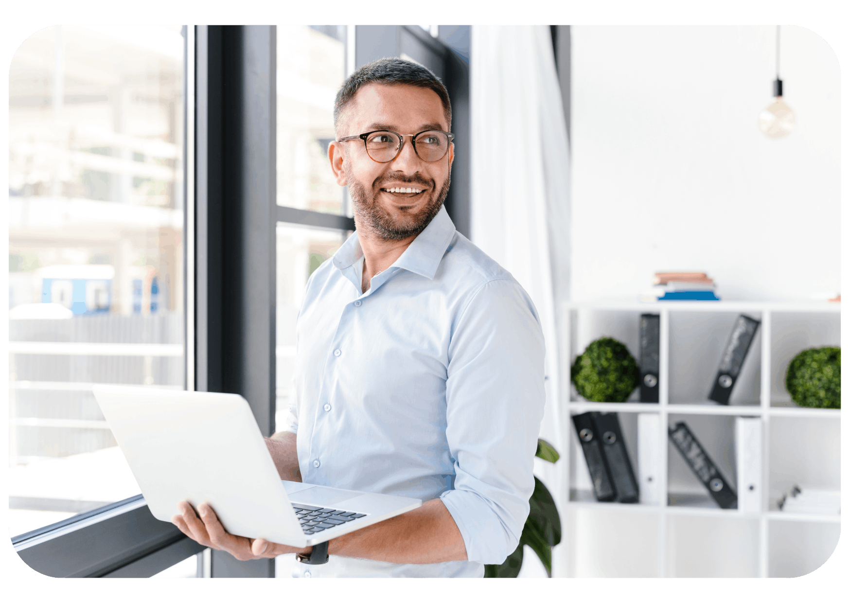 Man standing smiling with laptop