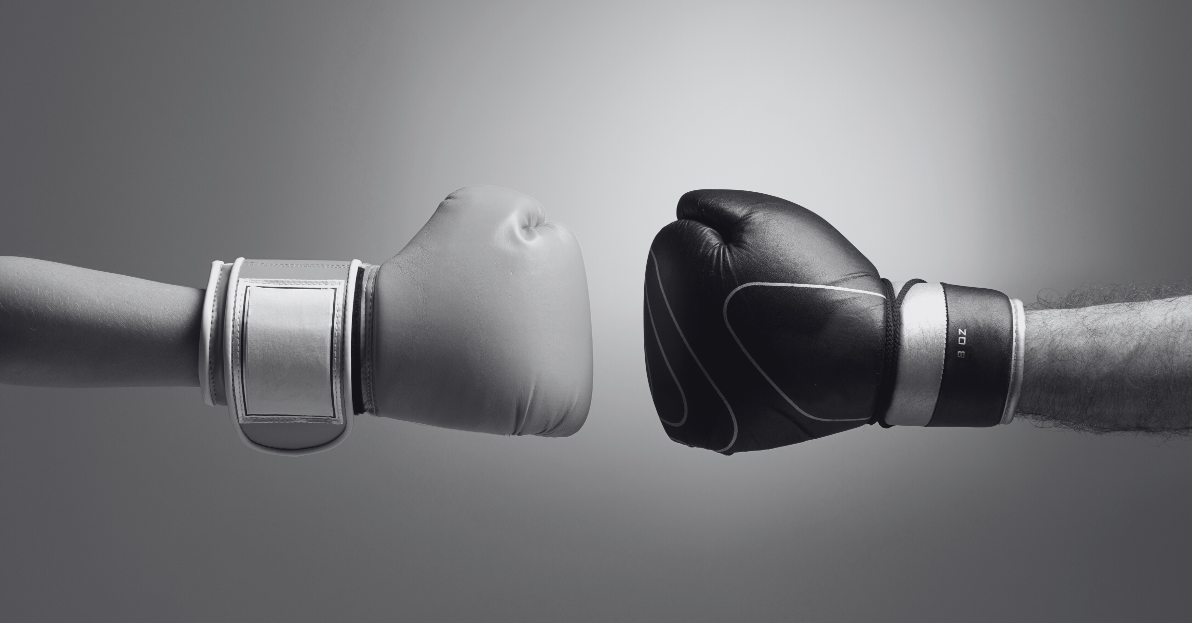 Two gloved hands symbolize the boxing match between two competing technologies.