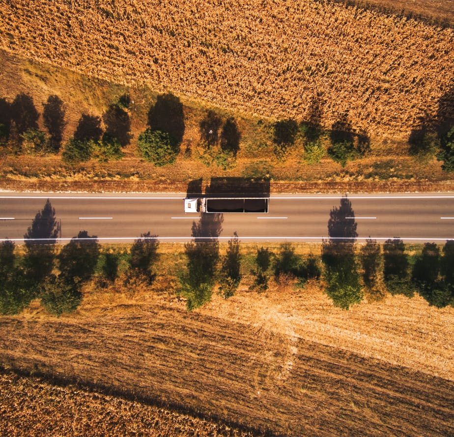 Aerial view of a delivery truck on the highway, representing efficient logistics in circular procurement, reducing carbon footprint.