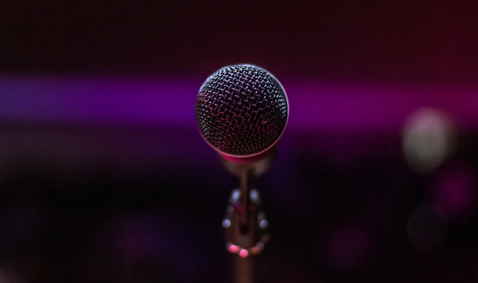 microphone zoomed in, fucsia backgroun