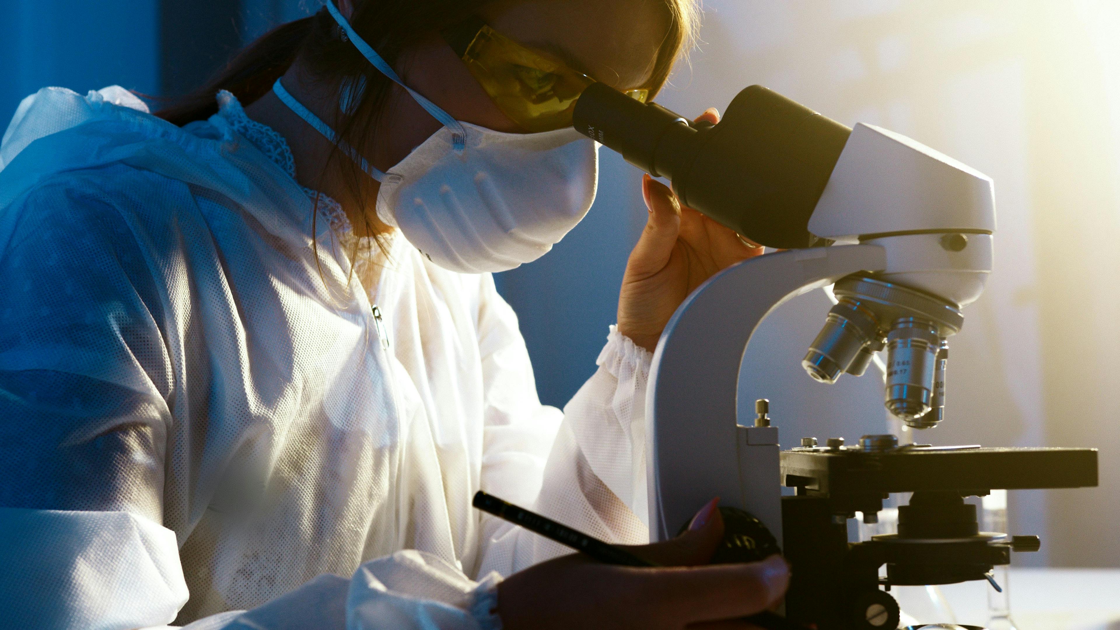 A woman looking into a microscope