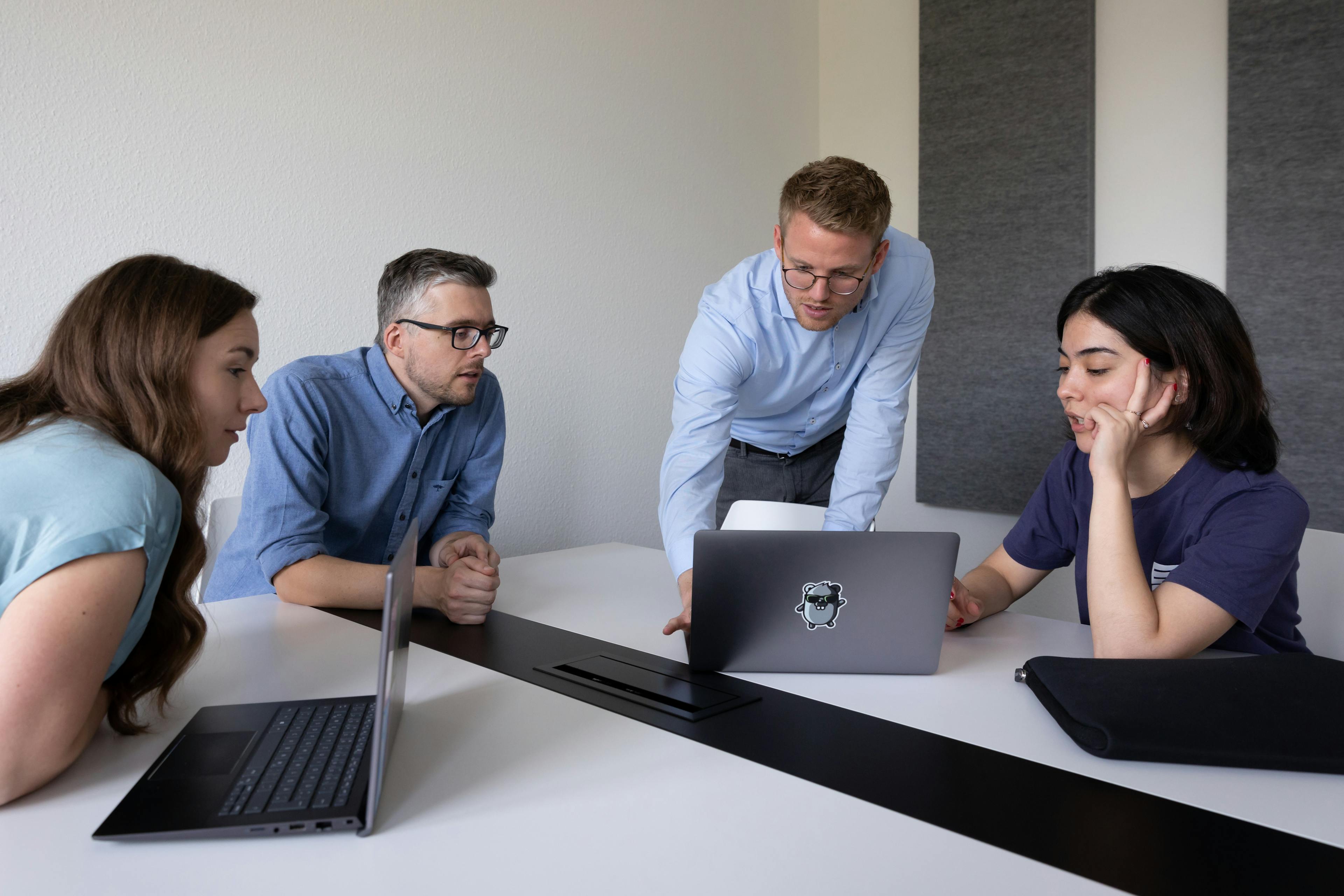 Edgeless Systems team, 4 people discussing in front of a laptop