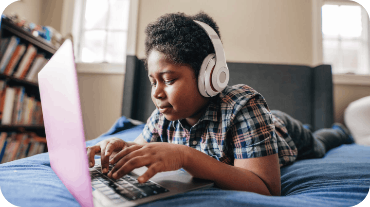 Child using a laptop and headphones