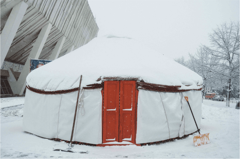 Yurt with red door in the snow