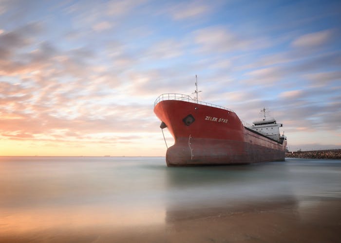 A photograph of a cargo vessel stationary in a bay