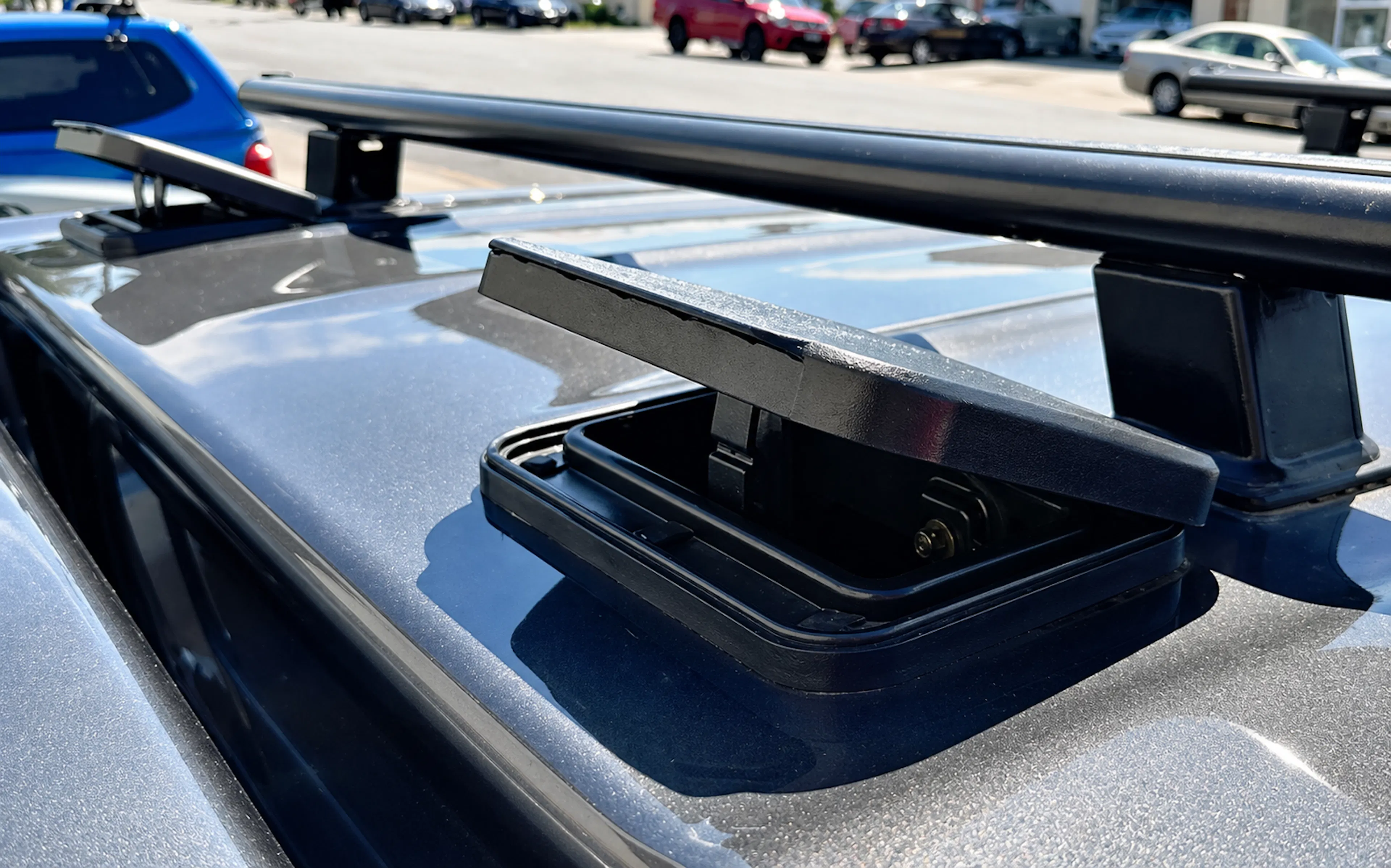 Open EGR canopy roof vent with black rack crossbars mounted on a metallic ute canopy roof.