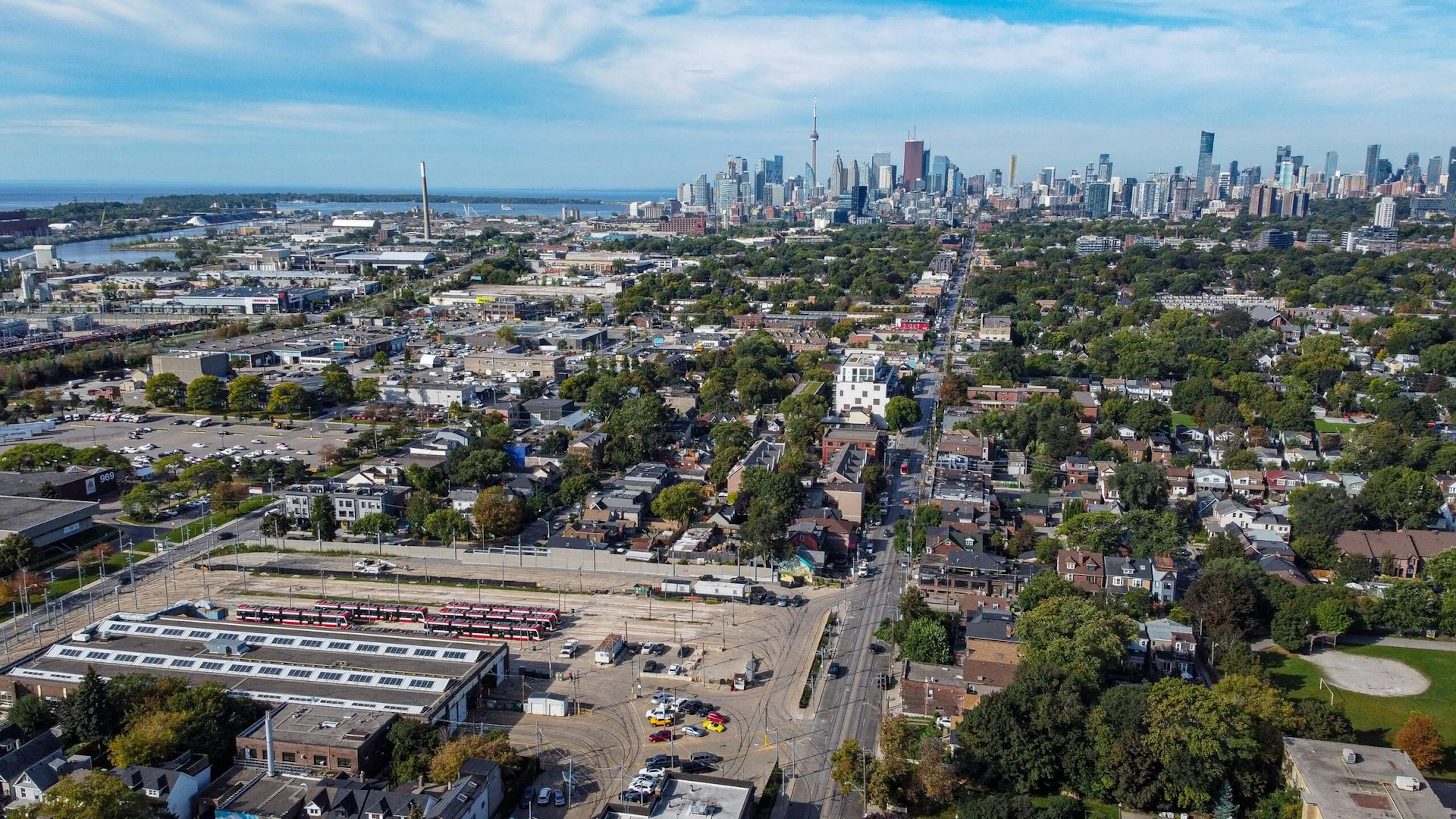 Aerial view over the Russell Carhouse yard and surrounding neighbourhood with the Toronto skyline behind