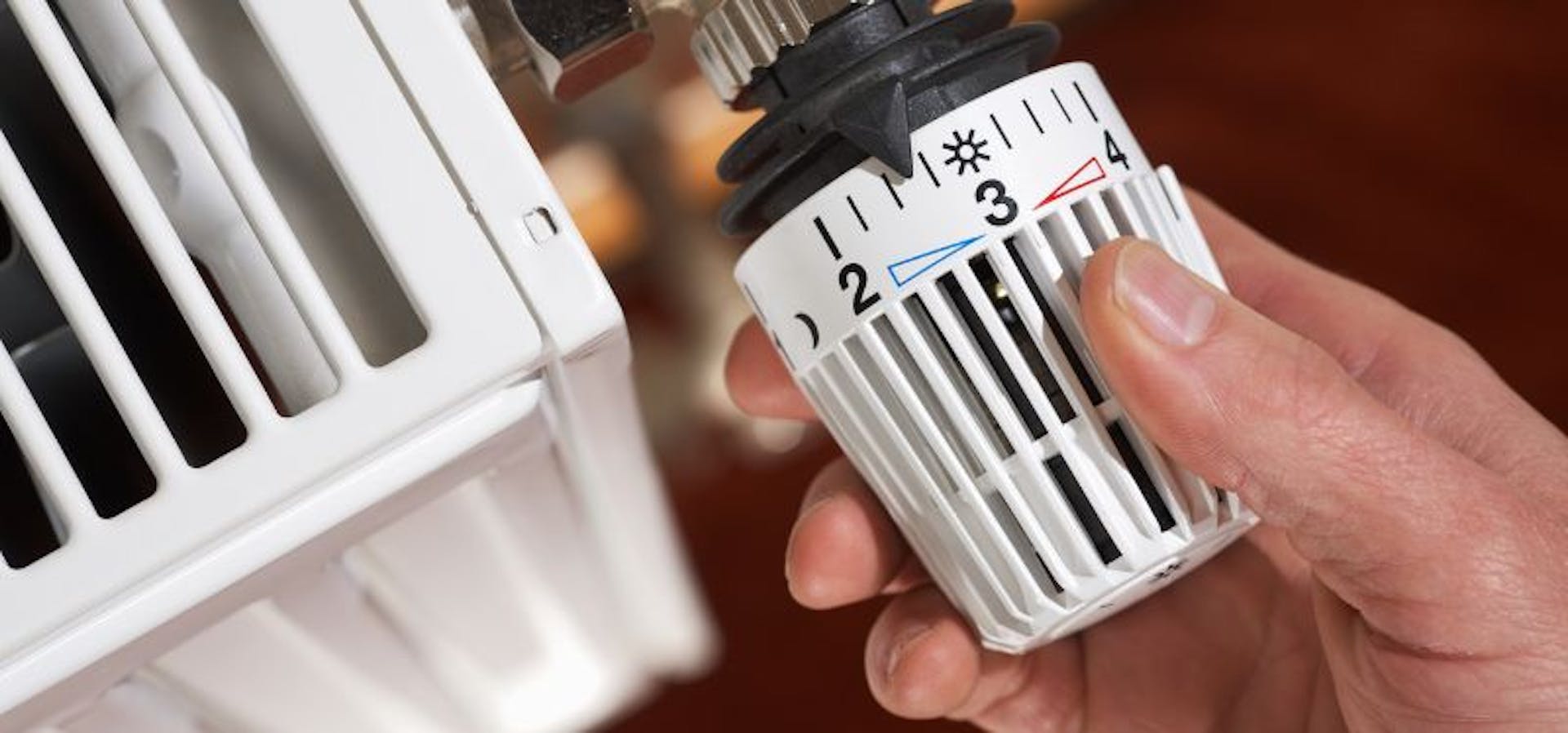 Personne qui règle le thermostat de son radiateur