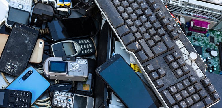 Une pile de smartphones, claviers et autres appareils numériques cassés : la pollution numérique