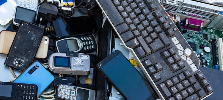 Une pile de smartphones, claviers et autres appareils numériques cassés : la pollution numérique