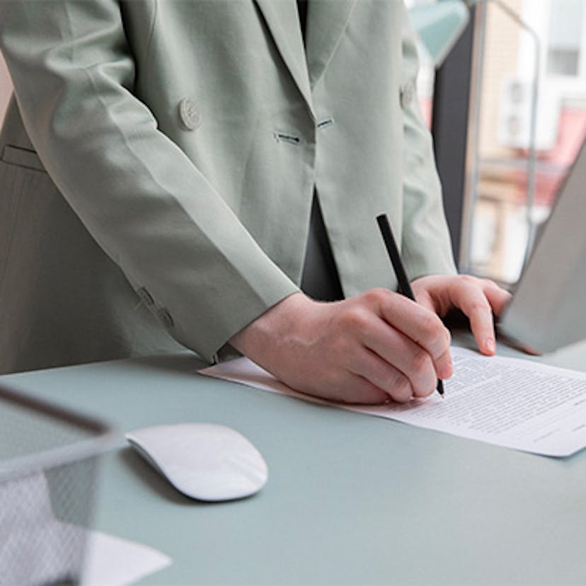 Une personne signant un contrat d'électricité Ekwateur, Direct Energie (anciennement Total Direct Energie) ou autre