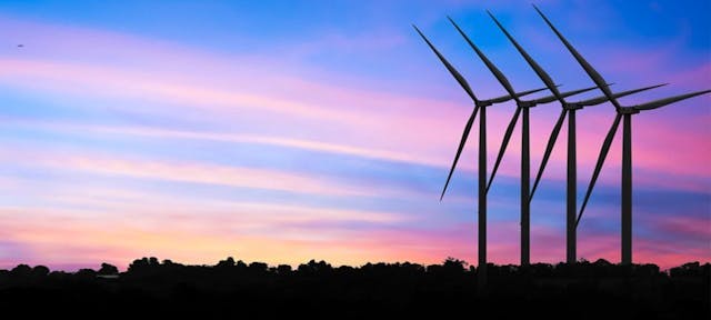 Des éoliennes sous un coucher de soleil