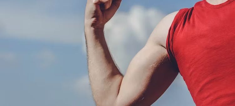Homme en rouge qui contracte un biceps