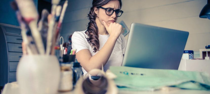 Une femme interrogative devant un ordinateur