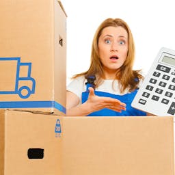 Une femme derrière tenant une calculatrice dans ses mains pour déménager pas cher