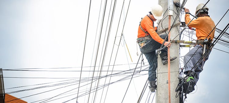 Des techniciens en train de réparer une ligne électrique