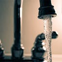 Un robinet qui coule qui représente la consommation d'eau