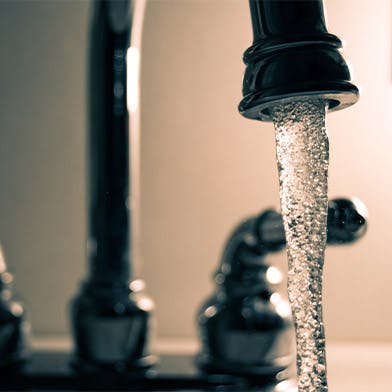 Un robinet qui coule qui représente la consommation d'eau