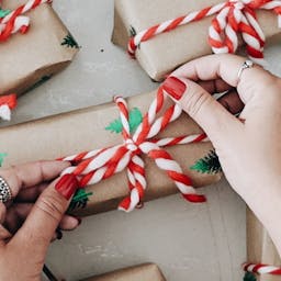 Main resserrant le nœud d'un papier cadeau