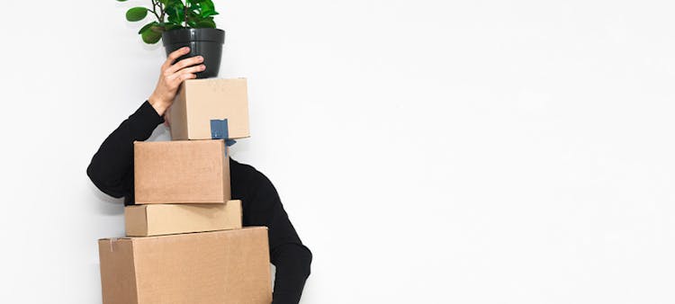 Un homme tenant des cartons essayant de faire un déménagement écologique
