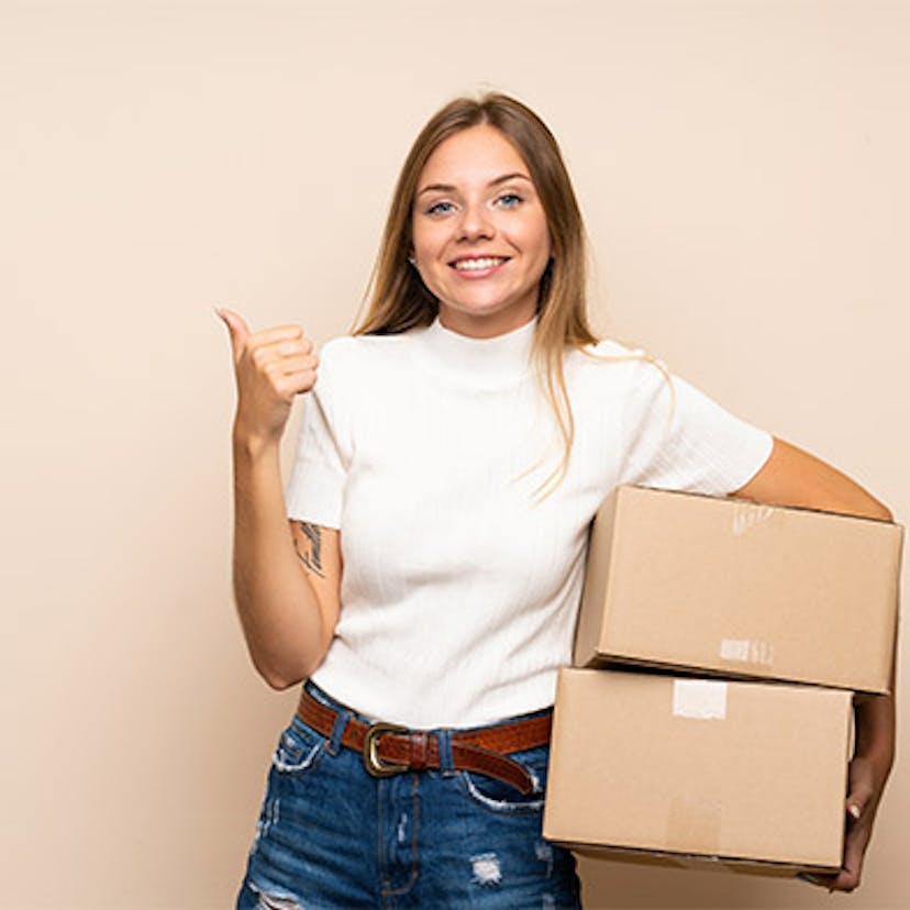 Une femme avec des cartons de déménagement dans les bras