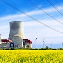 Champ avec une centrale nucléaire et des infrastructures d'énergies renouvelables