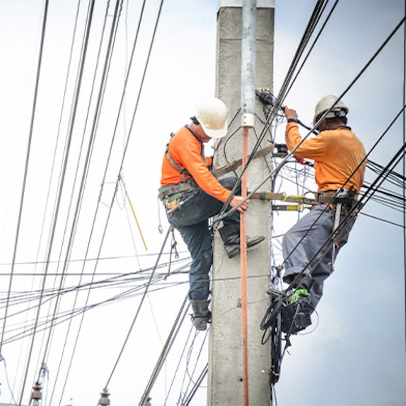 Des techniciens en train de réparer une ligne électrique