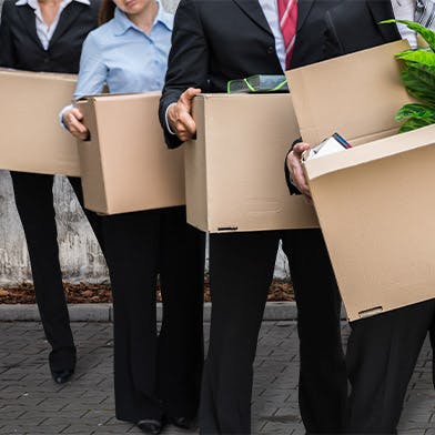 Des personnes debout tenant des cartons pour déménager leur entreprise de manière écologique