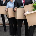 Des personnes debout tenant des cartons pour déménager leur entreprise de manière écologique