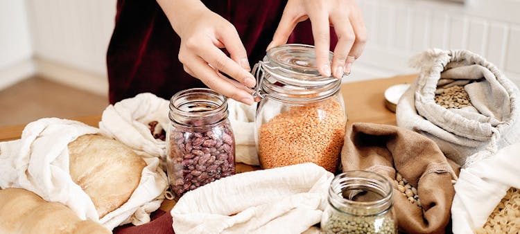 Une femme qui met des aliments dans des bocaux pour une cuisine zéro déchet