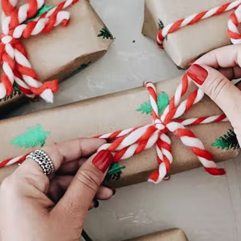 Main resserrant le nœud d'un papier cadeau