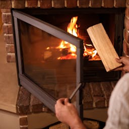 Personne qui utilise un insert pour réduire sa facture de chauffage.