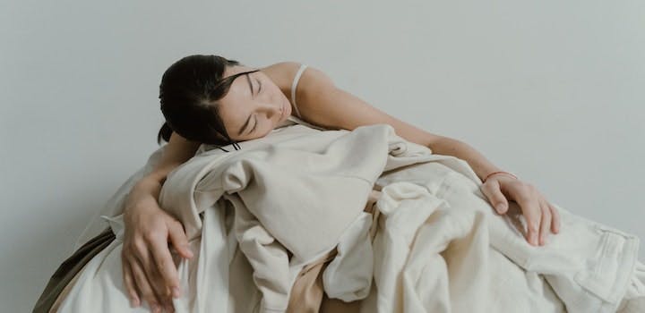 femme qui dort sur une pile d'habits