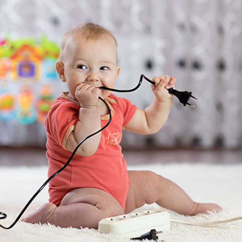 Un bébé avec une prise électrique dans la bouche